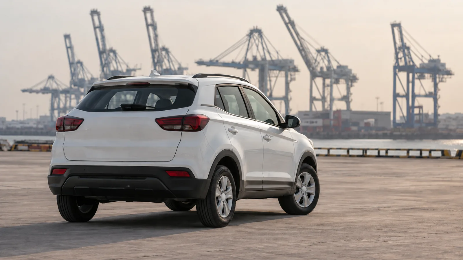 Illustrative unbranded white compact crossover in a generic Indian seaport vehicle holding area