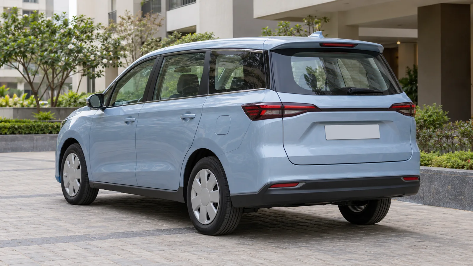 AI-generated generic unbranded pale blue electric family MPV in an Indian apartment forecourt, not an actual Kia Carens Clavis EV