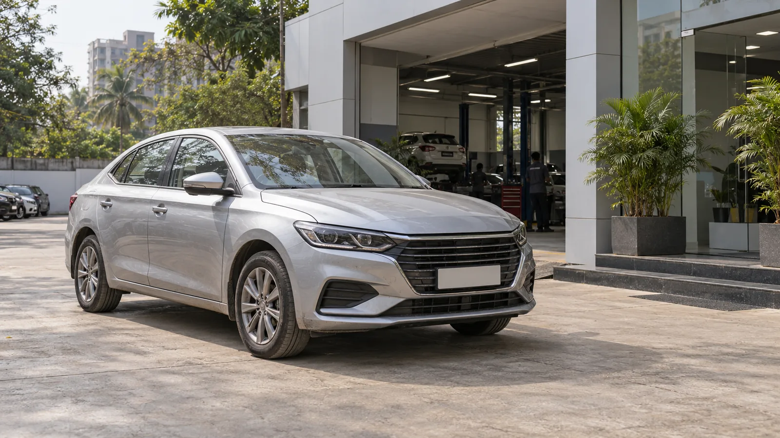 Illustrative unbranded silver sedan outside a service reception building in Maharashtra