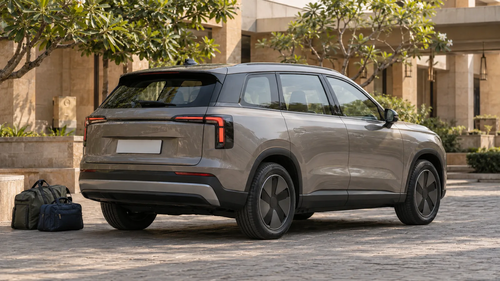 Illustrative generic champagne-grey large SUV with travel bags in a quiet Indian hotel courtyard